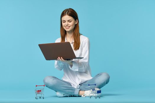 woman with laptop learning internet online education blue background. High quality photo