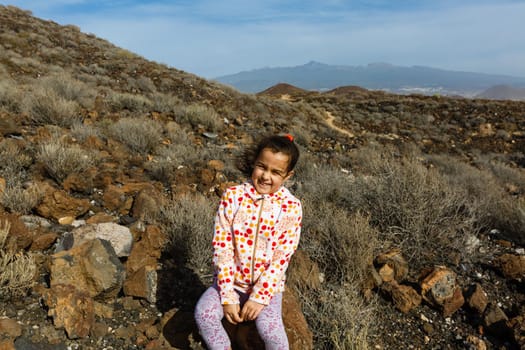 little girl stands near a cactus on the island of tenerife