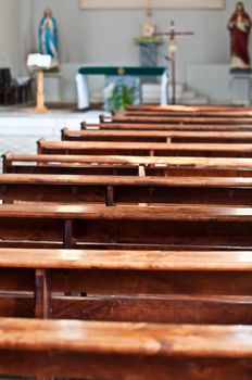 catholic church interior with front of seats in foreground with focus on it