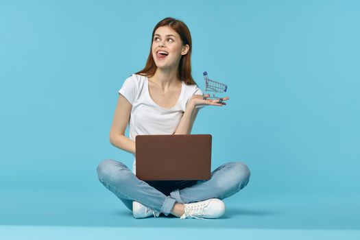 woman student sitting on floor with laptop education blue background. High quality photo
