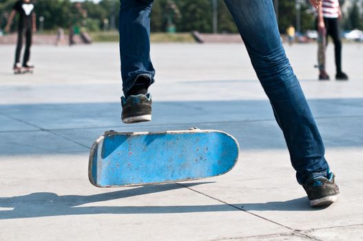 young skater perfoming stunt on his blue board