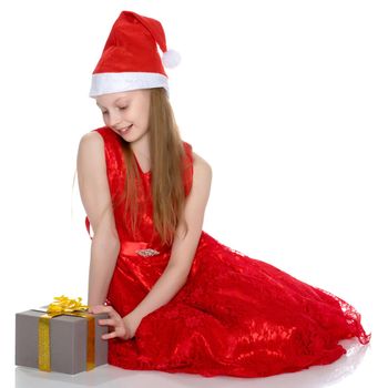 Beautiful little girl with a gift on a white background. Concept of a holiday, New Year and Christmas. Isolated.