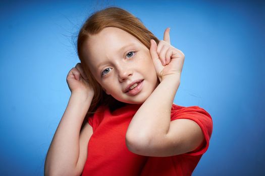 cheerful cute red-haired girl childhood blue background. High quality photo