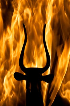 photo of the bull figurine with real flame background