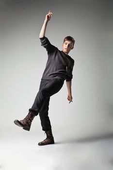 Full length portrait of a young fashion male jumping on grey background