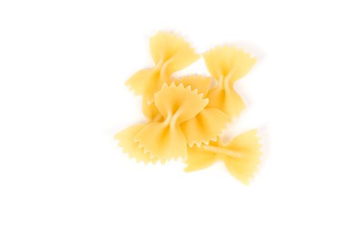 Close up of uncooked farfalle pasta against white background