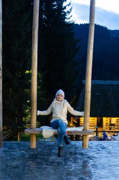 Caucasian woman sitting on swing. Concept of New Year inspiration and winter vacations