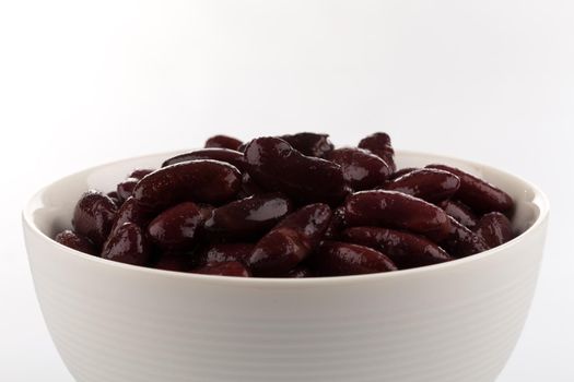 Red kidney beans in a dish in perspective. Isolated on white.