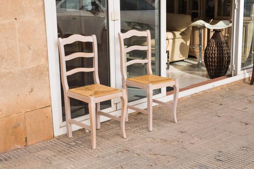 Two old wooden chairs standing on backyard.