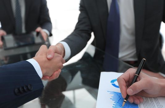 handshake of financial partners at the Desk.