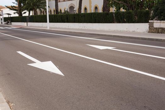 Arrow signs as road markings on a street with two lanes.