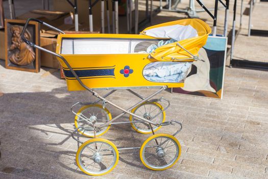 Vintage baby buggy or stroller, outdoors on flea market.