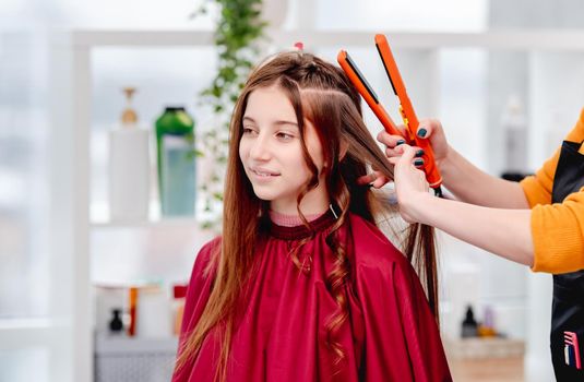 Portrait of long hair beautiful young model girl with curls during hairstyle process