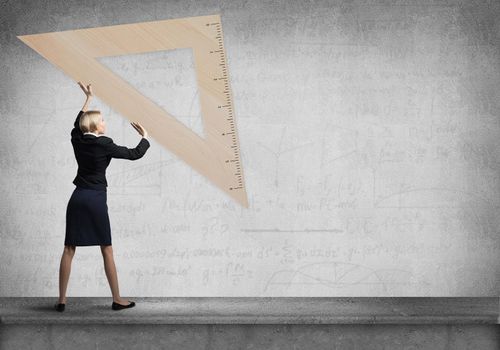 Woman holding big ruler on wall background. Testing and examination concept. Businesswoman measuring something with ruler. Human resources recruitment. Creative motivation, coaching and mentoring.