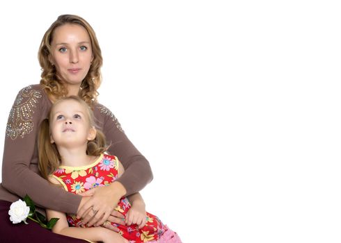 Young mother and little daughter gently embrace. The concept of Happy Childhood, Family Happiness, Raising a Child. Isolated on white background.