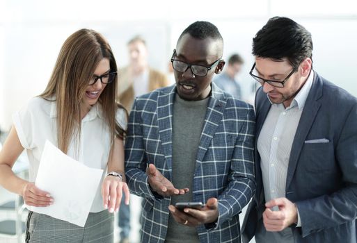 three colleagues looking at the smartphone screen.people and technology