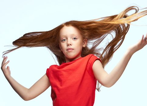 girl with red hair posing red t-shirt childhood. High quality photo