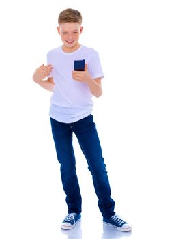 A small boy of school age uses a mobile phone. The concept of digital technology, communication between people. Isolated on white background.