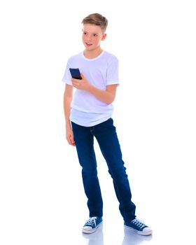 A small boy of school age uses a mobile phone. The concept of digital technology, communication between people. Isolated on white background.