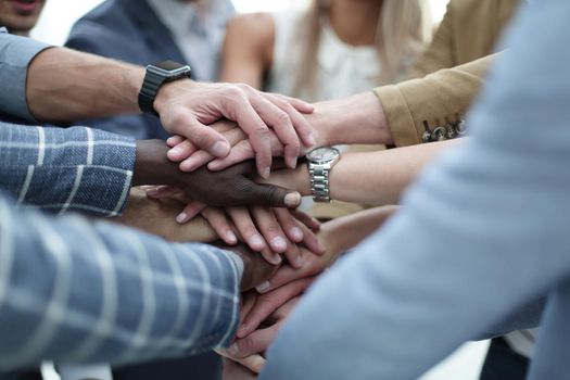 Concept of teamwork: Close-Up of hands business team showing unity with putting their hands together.