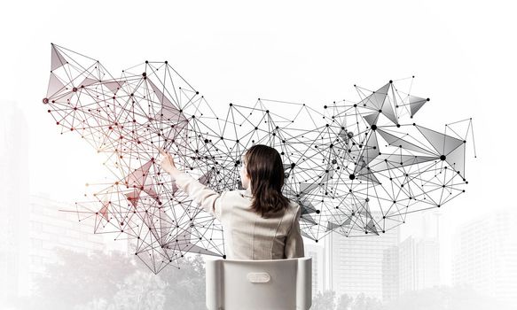 Businesswoman finger pointing on abstract network structure. Back view long haired woman in white suit sitting on white chair. Social connection and networking. Global cloud technology concept