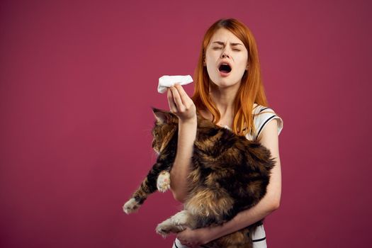 woman holding fluffy cat in her arms pet friendship pink background. High quality photo
