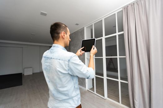 Smart Home: Man Controlling Blinds With His tablet.