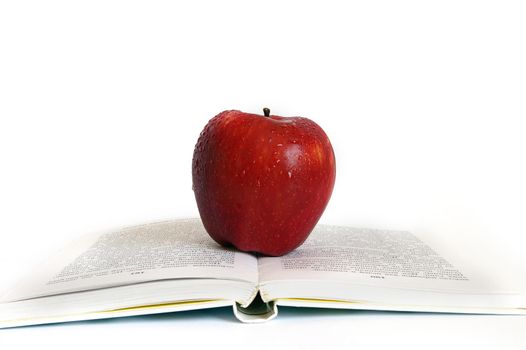 Red apple on the book isolated background