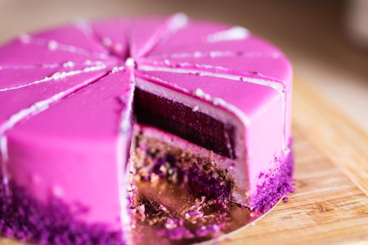 Pink and violet birthday cake without one piece. Dessert, holidays and delicious.