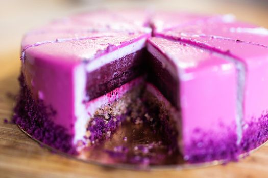 Pink and violet birthday cake without one piece. Dessert, holidays and delicious.