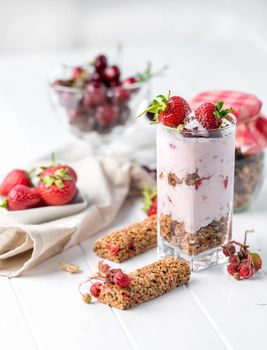 Tasty granola with nuts and yoghurt, berries on the side, healthy breakfast, sideview