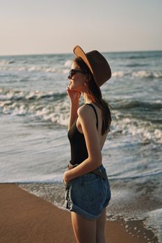 woman walking on the beach hat travel vacation sun. High quality photo