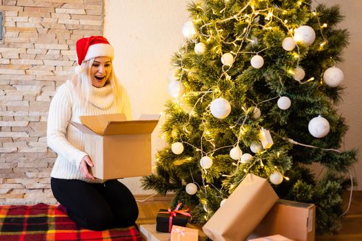Happy young woman opening a Christmas present box