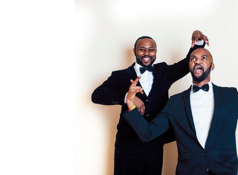 two afro-american businessmen in black suits emotional posing, gesturing, smiling. wearing bow-ties close up