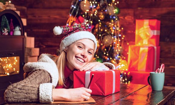 Cute blonde woman with Christmas gift. Girl celebrating noel party