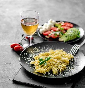 vegetarian dinner: pasta with parmesan cheese and tomato, mozzarella, avocado, nuts