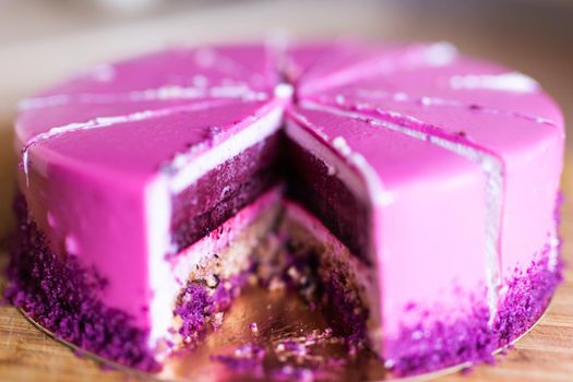 Pink and violet birthday cake without one piece. Dessert, holidays and delicious.