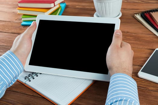 close-up of men's hands with a computer tablet. Businessman works in the office