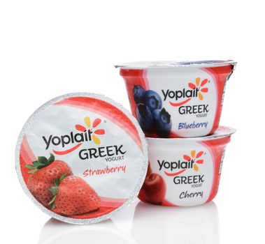 IRVINE, CA - SEPTEMBER 15, 2014: Three containers of Yoplait Greek Yogurt, Cherry, Strawberry, and Blueberry. In 1965, two French dairy co-operatives, Yola and Coplait, merged, becoming Yoplait.
