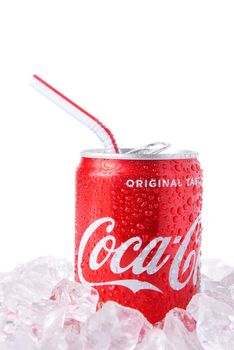 IRVINE, CALIFORNIA - MARCH 12, 2018: A can of Coca-Cola with drinking straw on ice. Coca-Cola is the one of the worlds favorite carbonated beverages.