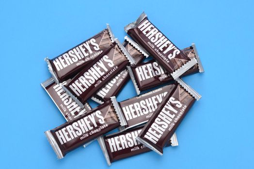 IRIVNE, CALIFORNIA - 3 JULY 2021: A pile of Hersheys Milk Chocolate Snack Size Candy Bars on blue.