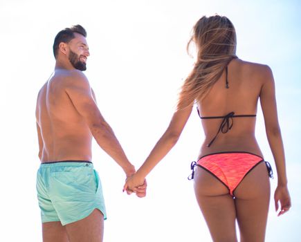 Detail of couple holding hands on beach holiday