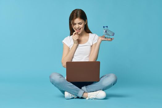 woman with laptop learning internet online education blue background. High quality photo