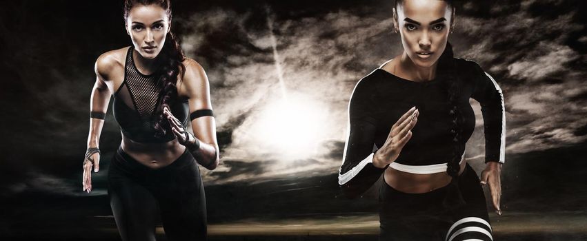 A Strong athletic, female runner on the sandy beach side at sunrise wearing a tight, dark fitness outfit.