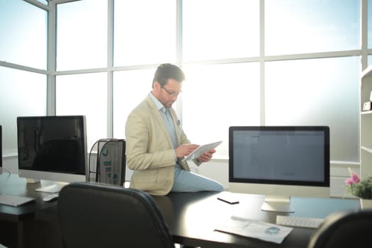 businessman with digital tablet sitting on office Desk.office weekdays