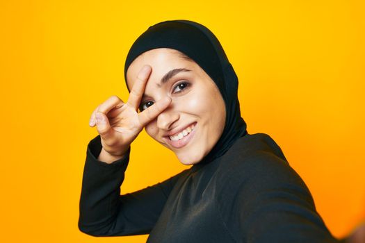 cheerful woman in black hijab posing fashion hand gesture isolated background. High quality photo