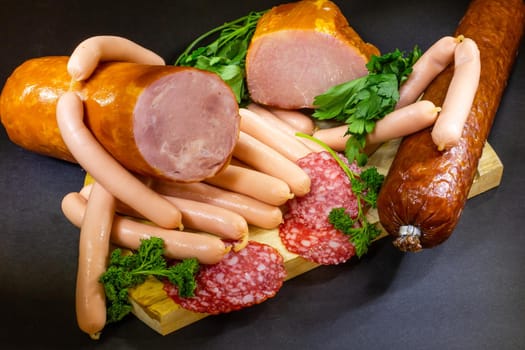 A composition of different sorts of sausages on dark background
