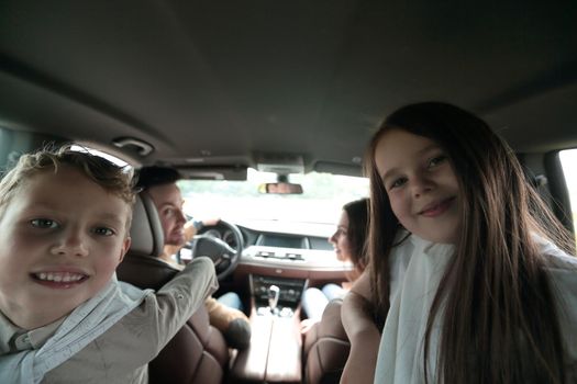 children sitting in the back seat of the car. family holiday