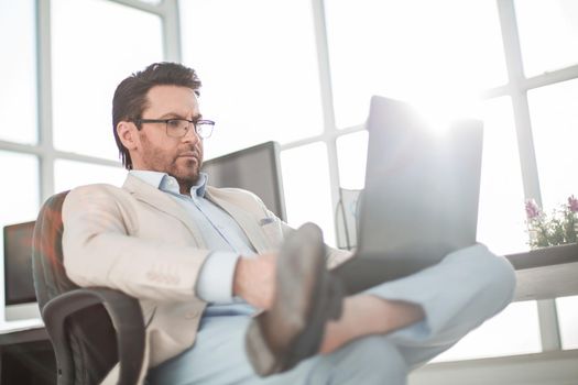 businessman using a laptop sitting at his Desk.people and technology