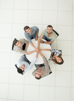 top view.smiling business team showing their unity .photo with copy space